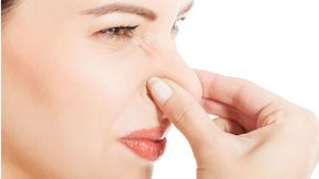 woman pinching her nose closed